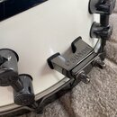Detailní záběr na bílý korpus bubnu s chromovaným hardwarem. Na držáku je vyryt nápis SONOR doprovázený logem značky. Povrch korpusu i chromované čás…
