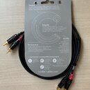 Fotografie znázorňuje dva černé audio kabely v originálním papírovém obalu. Na obalu jsou texty s nadpisy Passion, Integrity, Performance a Quality a…