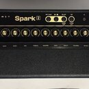 Černý kytarový kombo zesilovač s nápisem Spark 2. Horní ovládací panel obsahuje zlaté oválkové knoflíky, přepínače a vstup INPUT. Pod nimi jsou nápis…