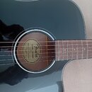 Tmavě zelená akustická kytara s vyřezem v korpusu. Uvnitř ozvučnice je vidět štítek s nápisy „Fender“, „CLASSIC DESIGN“ a „MODEL: CD-60“. Hmatník je…