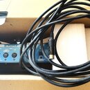 Na fotografii je modrý elektronický přístroj s nápisem Roland GR-55 GUITAR SY. Na předním panelu jsou vidět konektory OUTPUT R, L/MONO, PHONES a MIDI…