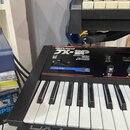 Černý klávesový syntetizátor s bílými a černými klávesami. Na horním panelu je nápis Roland, modelové označení JX-3P a text PROGRAMMABLE PRESET POLYP…