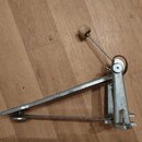 Kovový pedál basového bubnu v stříbrné barvě. Na horní části ramene je viditelný nápis "Made in Germany". Přední část pedálu obsahuje nastavovací šro…
