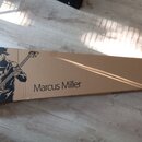 Kartonový obal v hnědé barvě s černým potiskem. Na krabici je nápis Marcus Miller a silueta hrajícího basisty s nástrojem. V levé části je vidět symb…