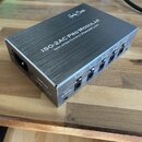Stříbrný kovový napájecí zdroj s broušeným povrchem. Na horní straně je nápis „Harley Benton“ a modelové označení „ISO-2AC PRO MODULAR ISOLATED OUTPU…
