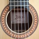Detailní pohled na ozvučnici akustické kytary světlého dřeva s ornamentálním rosetovým lemováním. Uvnitř ozvučnice je štítek s nápisy Guitarras Campo…