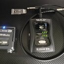Na fotografii je bezdrátový systém Line 6 Relay G30 složený z vysílače a přijímače. Černý vysílač nese nápisy LINE 6, RELAY G30 a TEPOS TRANSMITTER s…