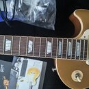 Detail elektrické kytary s hnědým trupem a hnedým hmatníkem s trapezoidními vložkami. Na kytaru je vidět jeden stříbrný humbucker a oválkový přepínač…