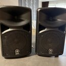 Dva černé plastové reproduktory s integrovanými rohmi v horní části. Na spodní mřížce obou reproduktorů je umístěno bílé logo a nápis YAMAHA. Povrch…