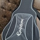 Černý polotvrdý pouzdro na kytaru s šedými lemovacími pruhy. Na přední kapsi je bílý nápis Epiphone a pod ním menší text Since 1870. Povrch pouzdra j…