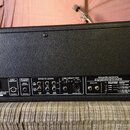 Zadní panel černého kytarového komba s texturovaným povrchem. Jsou zde vidět sekce FOOT SWITCH, REVERB CANCEL, EFFECTS LOOPS, LINE/DIRECT OUT, SPEAKE…