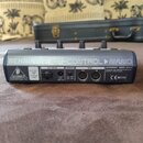 Zadní strana černého MIDI kontroléru s nápisem BEHRINGER B-CONTROL NANO. Na zařízení jsou vidět konektory AC INPUT, POWER a MIDI (OUT, IN), přepínač…