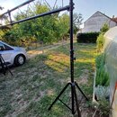 Černý kovový stativ s rozkládacími nohami, který drží vodorovnou konstrukci formou trámu. Povrch je černý a vykazuje mírné známky používání v podobě…