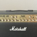 Kytarový kombozesilovač značky Marshall v černém krytí. Na ovládacím panelu jsou nápisy JCM 2000 - 60W a TSL602 Triple Super Lead. Panel obsahuje řad…