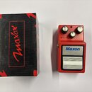 Červený efekt pedál s nápisem Maxon Compressor/Limiter. Na horní části jsou tři ovládací knoflíky a popisky RATIO, THRESHOLD, GAIN a kontrolka REDUCT…