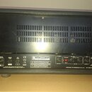Zadní strana černého zesilovače s ventilační mřížkou v horní části. Na spodním panelu jsou nápisy AMPLIFICATION, VHT, HAND BUILT BY ROCKERS IN THE U.…