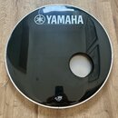Černý kruhový kryt s bílým okrajem a vyříznutým otvorem. V horní části je bílé logo a nápis YAMAHA. Dole jsou umístěny bílé nápisy UC, logo Remedy s…