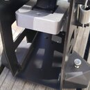Detailní pohled na černý kovový mechanismus bicího pedálu. Horní část tvoří chromovaný hřídel s černými gumovými prstenci a stříbrný kovový blok. Na…