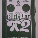 Zelená krabice s bílým potiskem schéma efekt pedálu. Na povrchu jsou nápisy VOL, SUSTAIN, BLEND, TONE, BASS BOOST a velký text BIG MUFF π2. Dole je u…