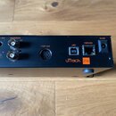 Zadní strana černého audio rozhraní s nápisem uTrack 24. Zařízení obsahuje konektory main out 1 a 2, wordclock in a out, midi out, usb, network a vst…