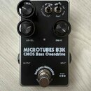 Černý efekt pedál s nápisy MICROTUBES B3K a CMOS Bass Overdrive. Na spodní části je logo Darkglass Electronics a označení napájení 9VDC. Pedál má dva…