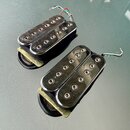 Dva elektrické kytarové snímače typu humbucker s chromovaným krytem a viditelnými poloslníky. Snímače mají připojené elektrické vodiče a jsou zespodu…