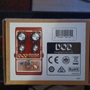 Kartonová krabice s obrázkem červeného efekt pedálu. Na pedálu je nápis bob MEATBOX SUBSYNTH a ovládací prvky s popisky OCTAVE, OUTPUT, HI a LOW. Ved…