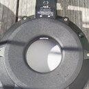 Fotografie znázorňuje zadní stranu černého kruhového trigger padu z plastu. Na horní části je štítek s nápisy Roland, PDX-8 DUAL TRIGGER PAD a dále t…