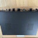 Černý efektový pedál nebo kontrolér v kovovém šasi s matným povrchem. Horní panel obsahuje několik černých otočných potenciometrů, přepínače a jeden…
