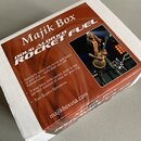 Kartonová krabice s červeným potiskem, na které je zobrazen hudebník s kytarou. Na krabici jsou nápisy Majik Box, DOUG ALDRICH a ROCKET FUEL. Text dá…
