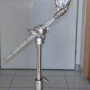 Stříbrný kovový mikrofonní stojan s boom ramenem a šedým držákem na mikrofon. Na spodní části stojanu je vidět modrý nápis YAMAHA. Povrch kovu vykazu…