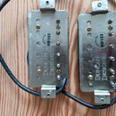 Dvě elektrické kytarové snímače v kovových krytech stříbrné barvy. Na obou je vyražen nápis DUNCAN DESIGNED a nalepená kulatá etiketa s textem DUNCAN…