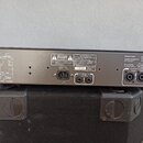 Zadní strana černého rackového zesilovače s bílými technickými schématy a nápisy. Na panelu jsou vidět konektory pro napájení AC INPUT 120V-60Hz a dv…