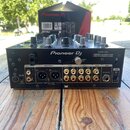 Černý DJ mixér Pioneer DJ model DJM-450 s nápisem DESIGNED BY ALPHATHETA IN JAPAN CONÇU par ALPHATHETA AU JAPON. Zadní panel obsahuje různé konektory…
