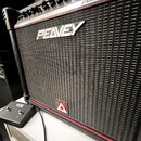 Černý basový kombozesilovač s černou textilní maskou a červeným lemem. Na horní části masky je stříbrné logo PEAVEY a vlevo nápis TRANS TUBE SERIES.…