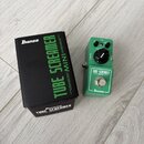 Zelený efekt pedál Ibanez Tube Screamer Mini v kompaktním kovovém provedení. Na pedálu jsou nápisy TONE, DRIVE a LEVEL u ovládacích knoflíků, dále OU…