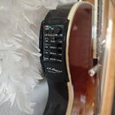Detailní pohled na černý předzesilovač s ekvalizérem zabudovaný v boční straně akustické kytary. Na panelu jsou nápisy LR-F Hybrid, BASS, MIDDLE a TR…