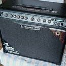 Černý kytarový kombozesilovač s textilní maskou reproduktoru. Na předním panelu je nápis LINE 6 a v dolní části texty 75 Watts, 400+ presets a 12" CE…