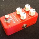 Červený efekt pedál s bílými ovládacími knoflíky. Na horní straně je nápis VALETON a vedle něj text COMPRINCE VINTAGE COMPRESSOR. K dispozici jsou čt…