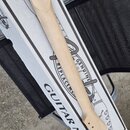Dřevěný krk elektrické kytary v přírodní barvě bez hmatníku a pražců. Položen je na bílém papírovém obalu s nápisy GUITAR NECK a GENUINE REPLACEMENT.…