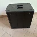 Černý hranatý reproduktor s texturovaným povrchem. Horní strana obsahuje úchopovou rukojeť a kruhový otvor pro osazení stativového držáku. Na povrchu…