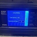 Detail ovládacího panelu světelného efektu s modrým displejem. Na levé straně jsou nápisy ROBIN®, BMFL WashBeam a logo ROBE®. Displej zobrazuje text…