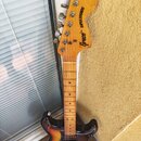 Elektrická kytara s t bodies v barevnosti sunburst a světle hnědým hnedem krku. Na hlavě je černý nápis Greco a SUPER SOUNDS. Tělo vykazuje známky op…