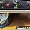 Detailní pohled na přední panel černého zařízení s nápisy SR 40 MULTI FREQUENCY, AKG a FLEXX PRO DIVERSITY. Na panelu jsou dvě černé ovládací knoflík…