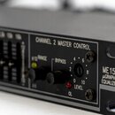 Detailní záběr na ovládací panel černého elektronického zařízení. Na panelu je nápis CHANNEL 2 MASTER CONTROL, tlačítko BYPASS a otočný ovladač s ozn…