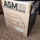 Kartonová krabice s nápisem ASM10 ACTIVE COAXIAL STAGE MONITOR. Na boku je schéma monitoru, piktogramy s pokyny k manipulaci a nápisy CE EAC Made in…