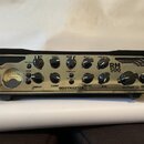 Stříbro-černý basový zesilovač s nápisem ROOTMASTER a označením RM 500 EVOLUTION. Přední panel obsahuje řadu ovládacích knoflíků s popisky jako BASS,…