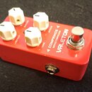 Červený efekt pedál s bílými oválnými ovladači. Na horní straně jsou nápisy COMPRINCE VINTAGE COMPRESSOR a VALETON, dále popisky SUSTAIN, ATTACK, TON…