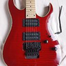 Elektrická kytara s červeným lakem a viditnou strukturou dřeva. Má dva černé humbuckery, černý tremolo systém a dva černé oválné knofíky. Kytara má s…