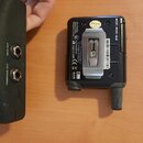 Fotografie zachycuje zadní stranu černého elektronického zařízení s kovovým klipem. Na povrchu jsou nápisy: „Pal Proding Made in China Designed in U.…